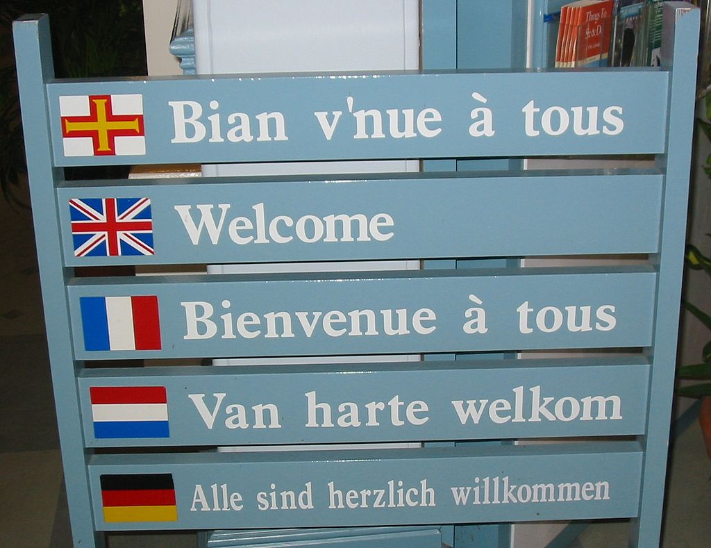 Multilingual welcome sign (Guernésiais on top) at Guernsey tourist information